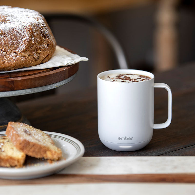 A delicious mocha latte sits next to a freshly baked coffee cake.