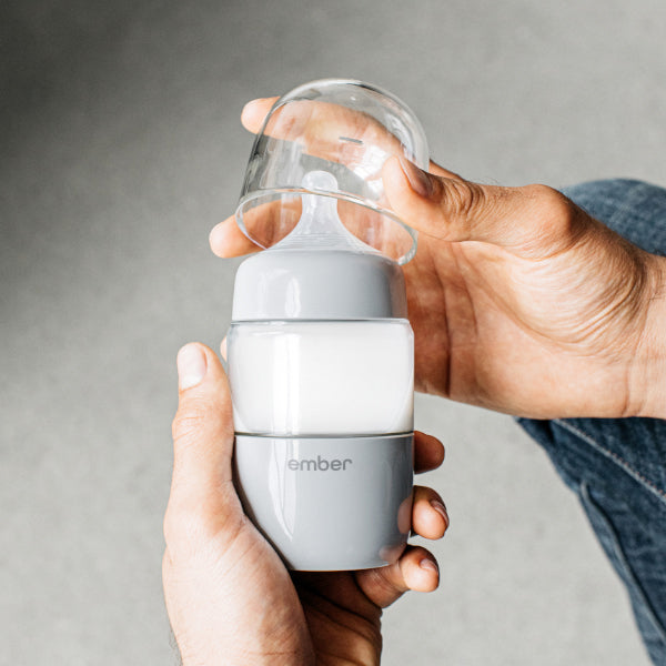 Parent Holds the Ember Baby Bottle filled with milk.