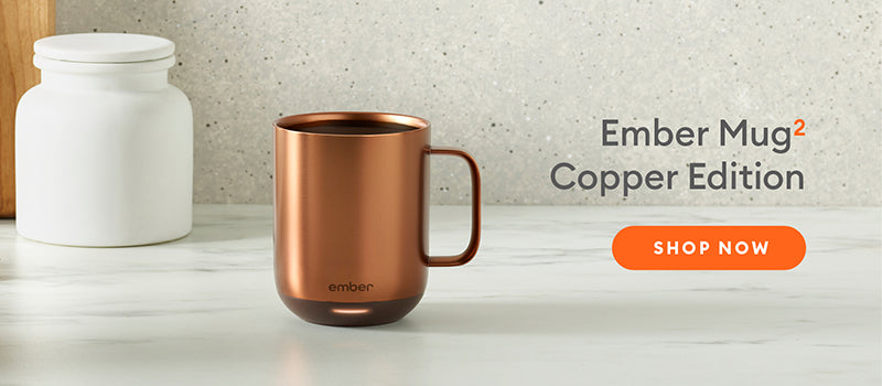Ember Mug²: Copper Edition on a marble countertop with a cream speckled wall.